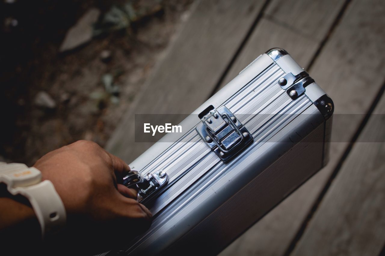 Cropped image of hand holding suitcase