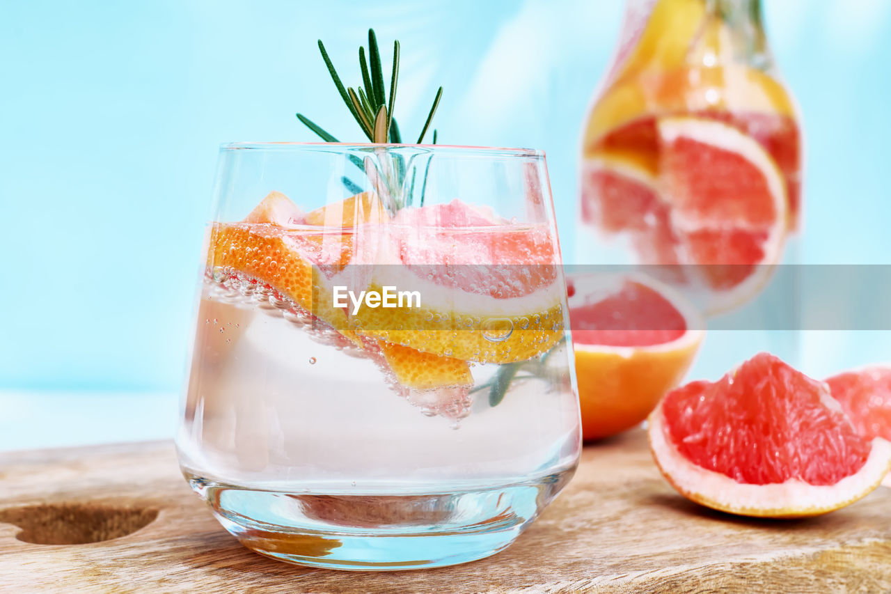 Summer cocktail with grapefruit and rosemary and juicy slices citrus fruits. fresh healthy drink