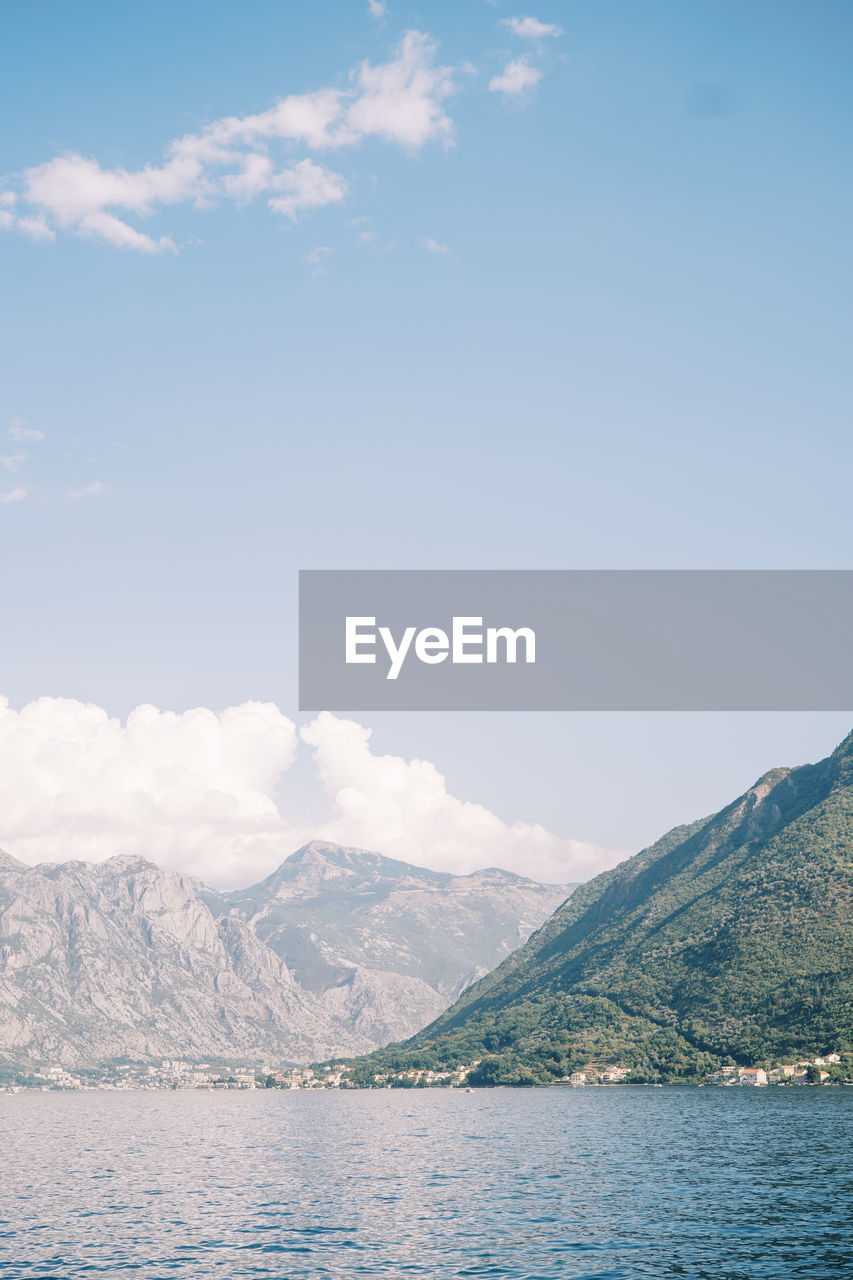 scenic view of sea and mountains against clear blue sky