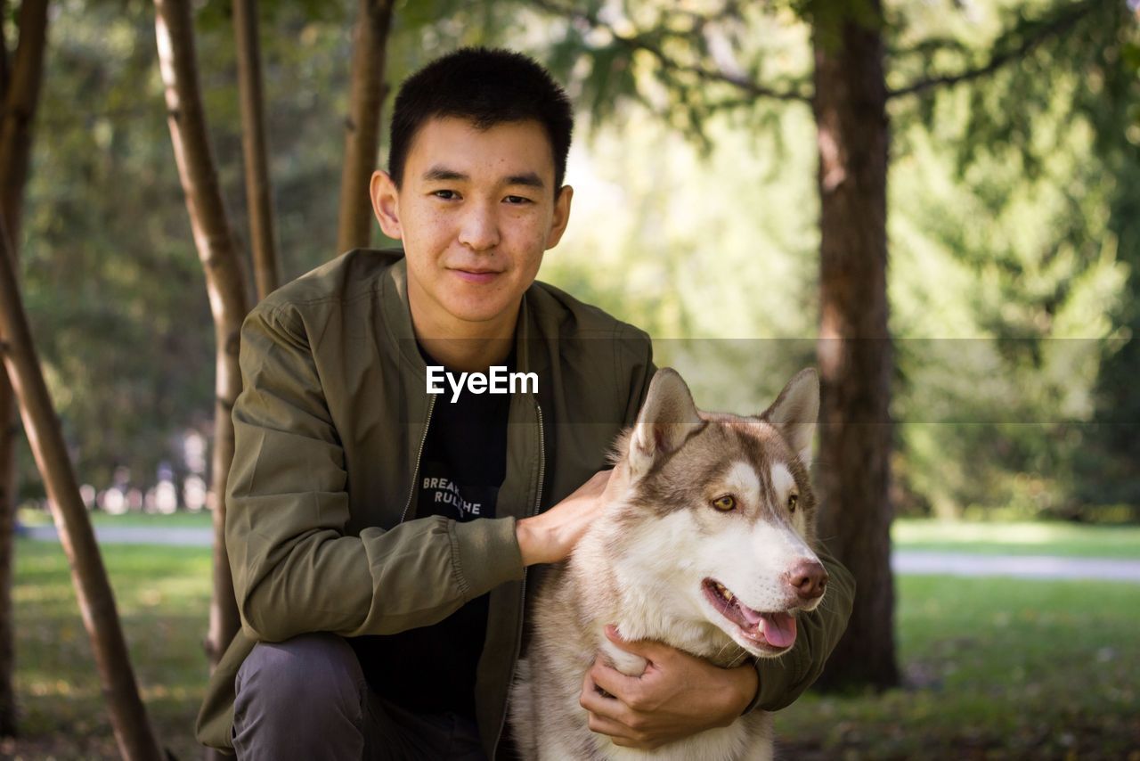 PORTRAIT OF YOUNG MAN WITH DOG