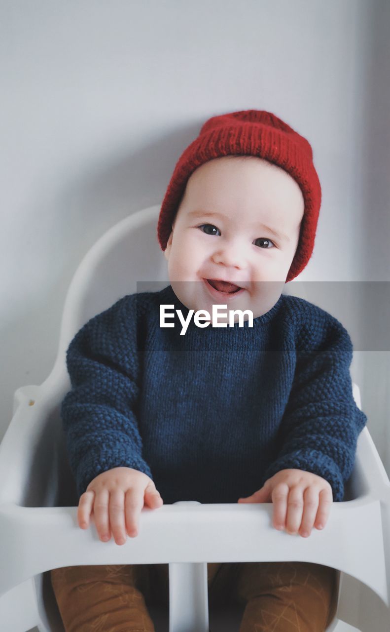 Portrait of cute baby boy sitting on high chair