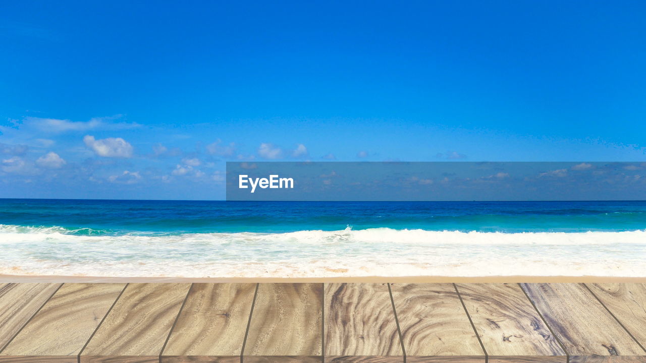 SCENIC VIEW OF BEACH AGAINST BLUE SKY