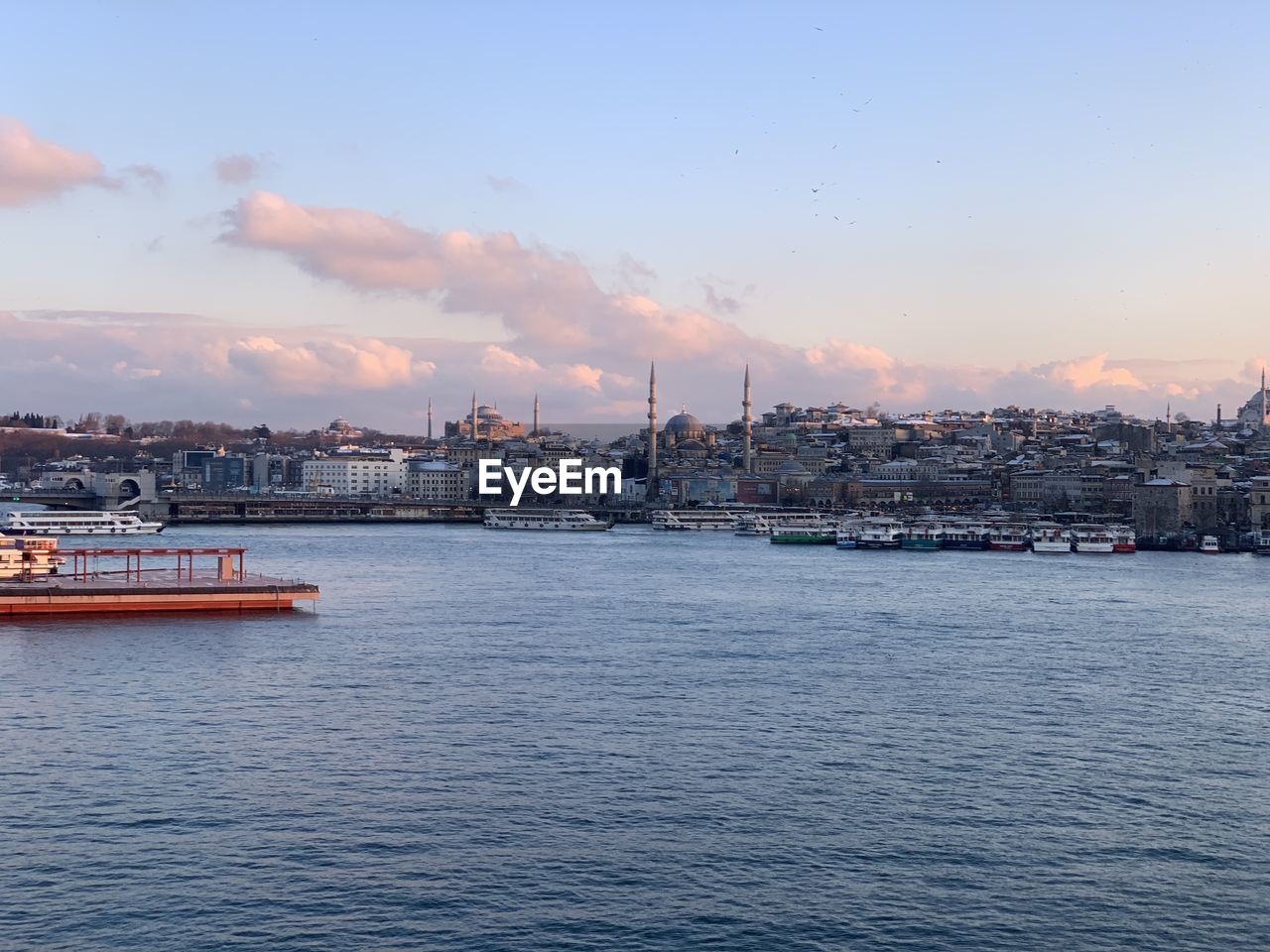 Scenic view of sea by buildings against sky during sunset