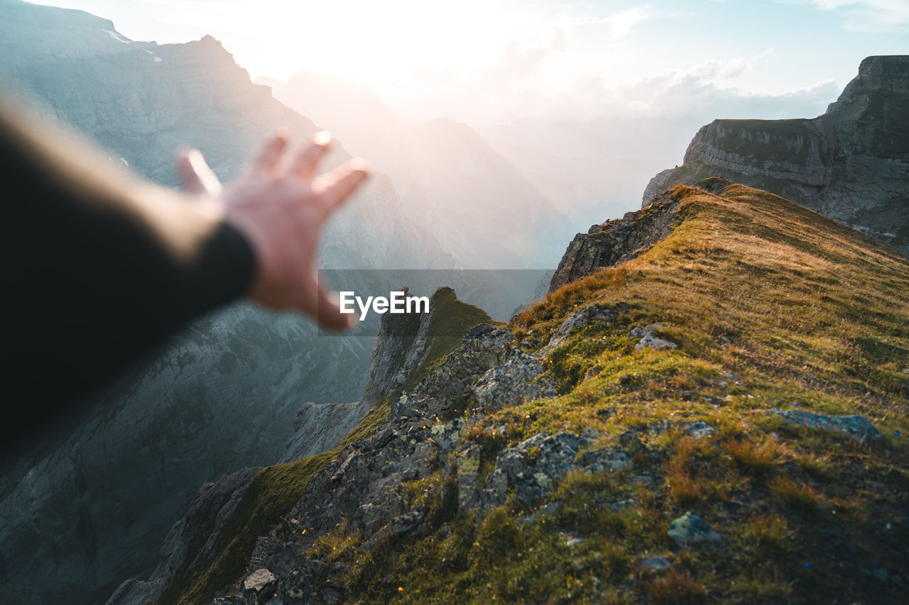 Cropped hand of man in front of rock