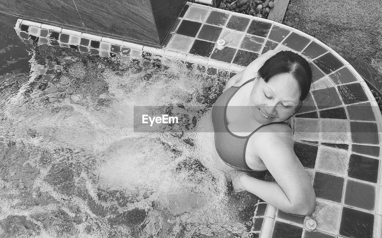 Portrait of young woman swimming in pool