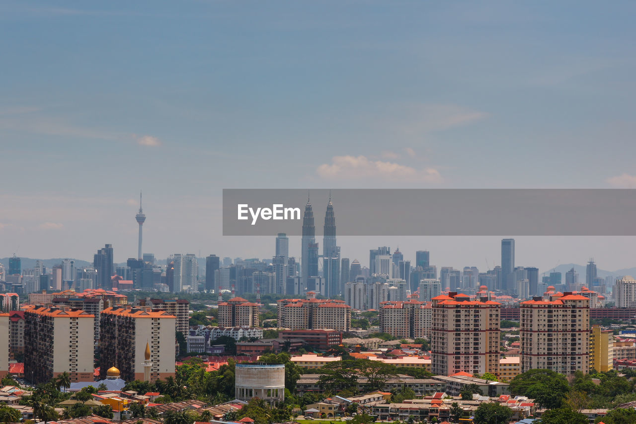 Petronas towers and kuala lumpur tower in city against sky