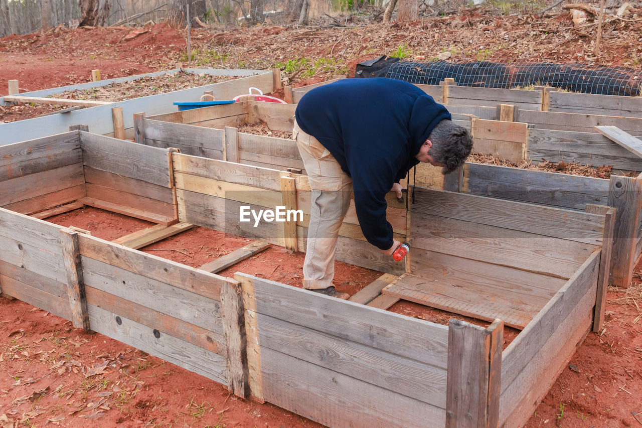 rear view of man walking on wooden wall