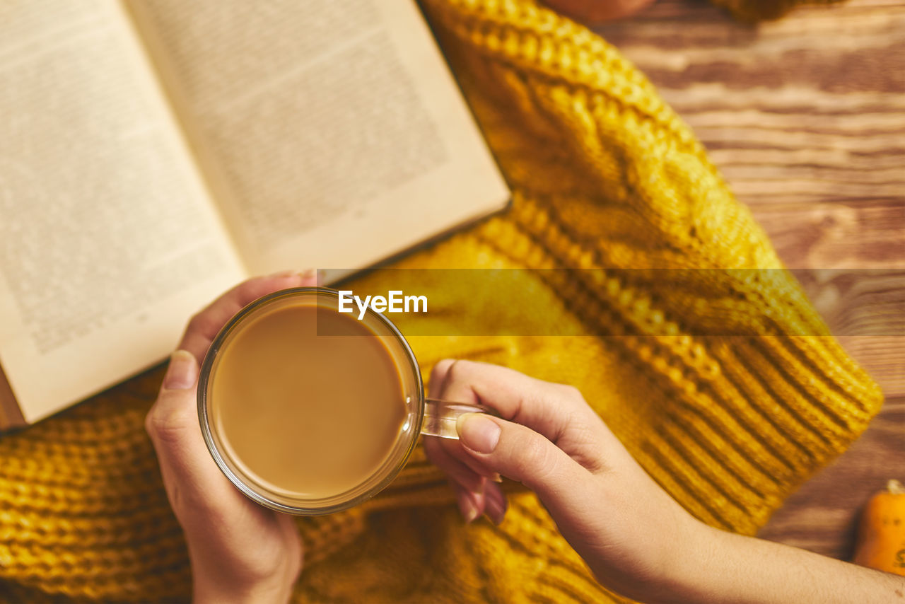 MIDSECTION OF WOMAN HOLDING COFFEE