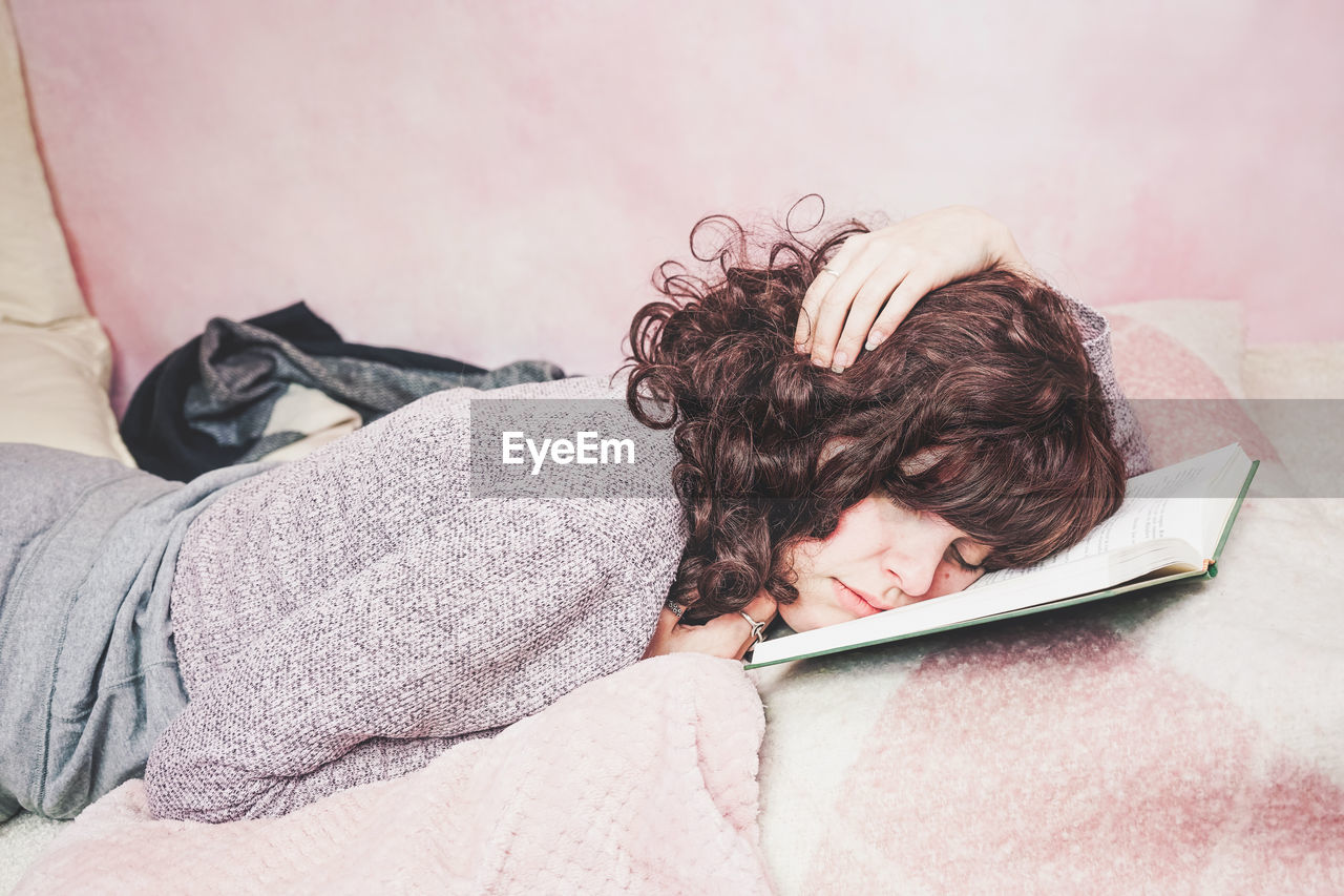 HIGH ANGLE VIEW OF WOMAN LYING DOWN ON BED