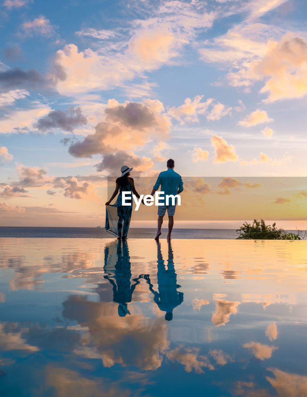 silhouette man standing on beach against cloudy sky during sunset