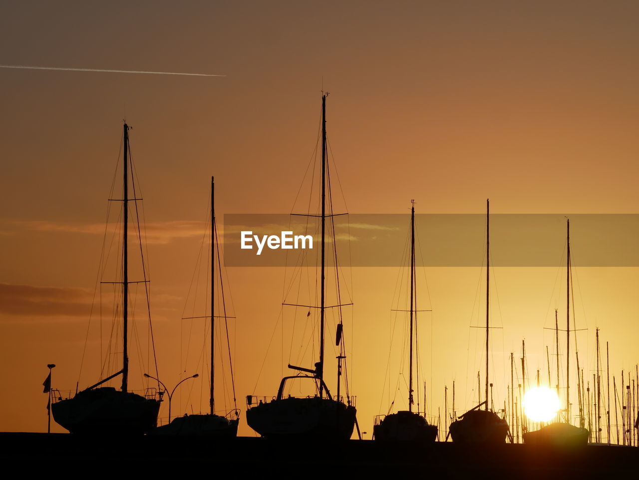 SILHOUETTE SAILBOATS MOORED AT HARBOR AGAINST SKY DURING SUNSET