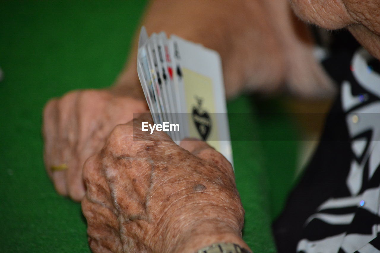 Senior woman playing cards at table