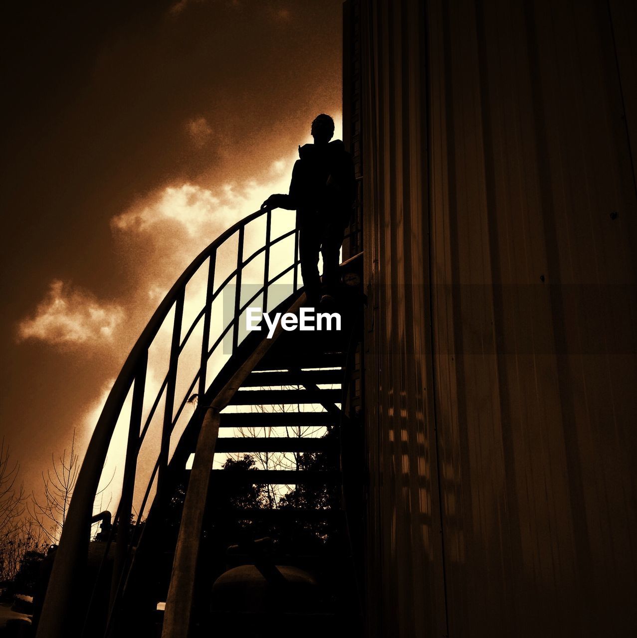 Low angle view of silhouette person on staircase against sky