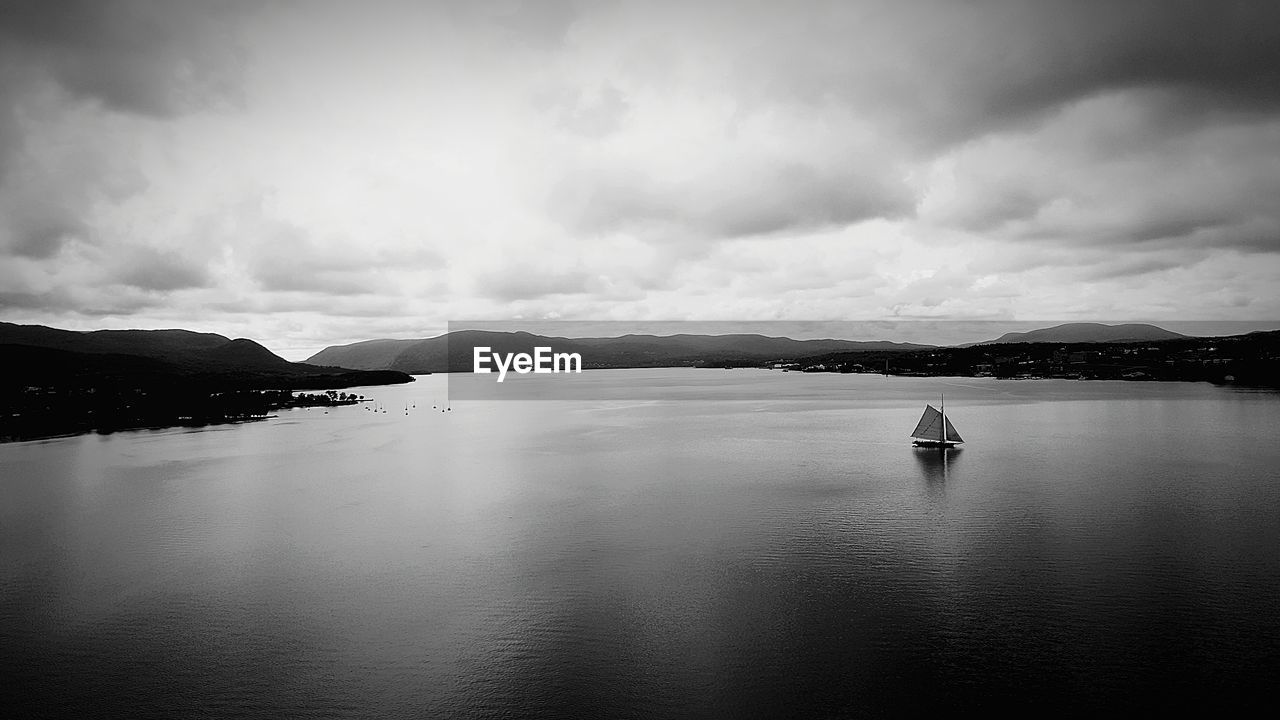 BOAT SAILING ON SEA AGAINST SKY