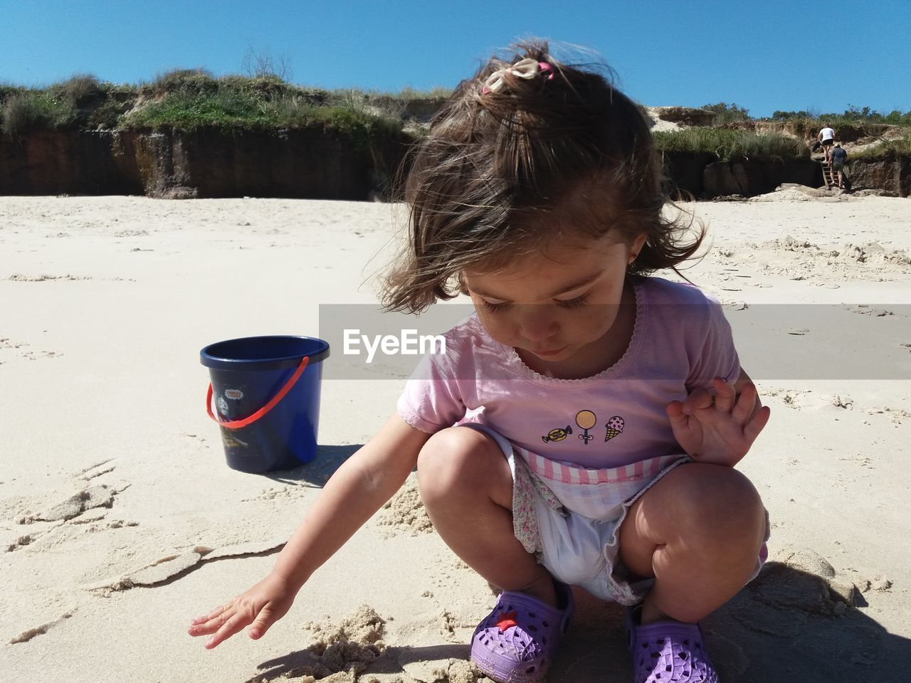 GIRL SITTING ON BEACH