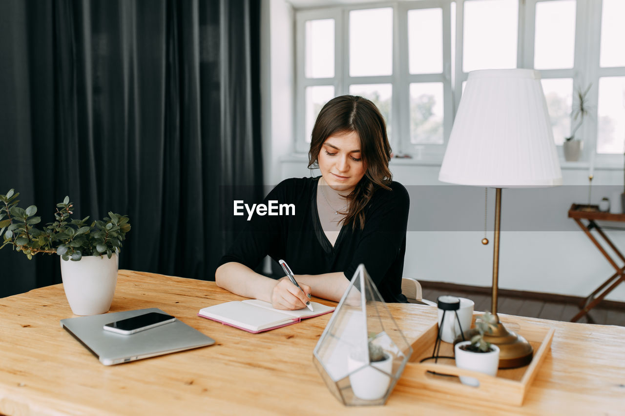 Business girl freelancer in casual clothes works using wireless technology in the home office