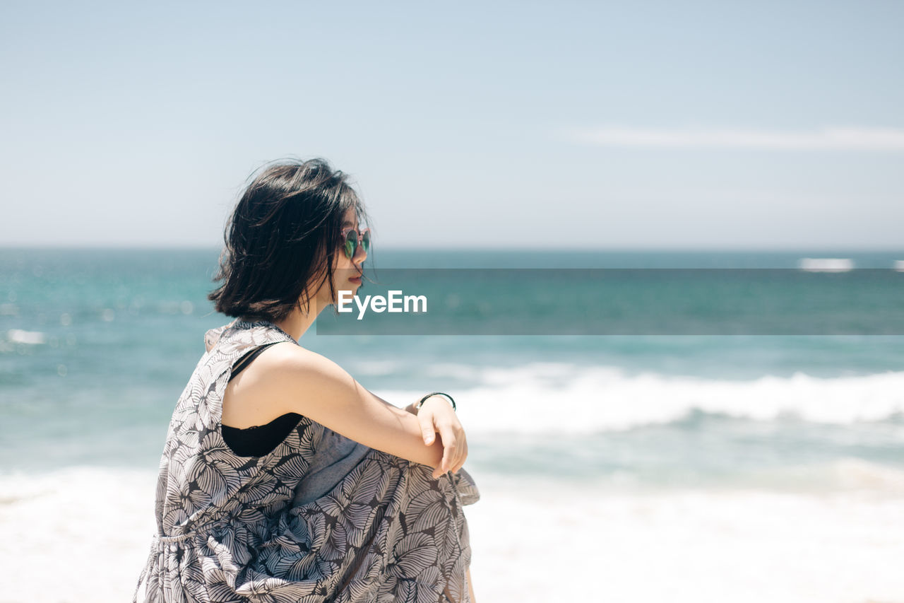 WOMAN LOOKING AT SEA SHORE