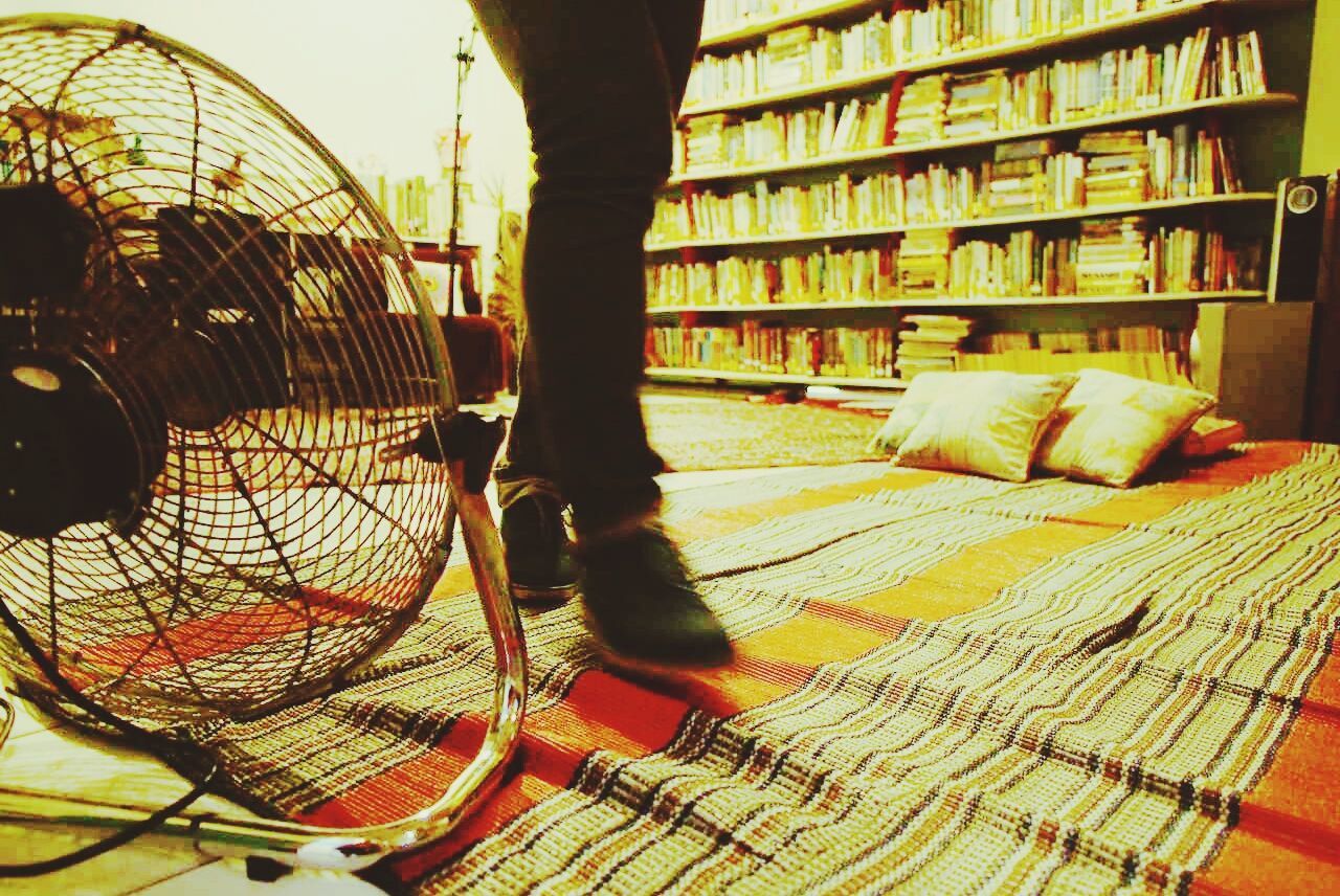 Woman walking on carpet past fan