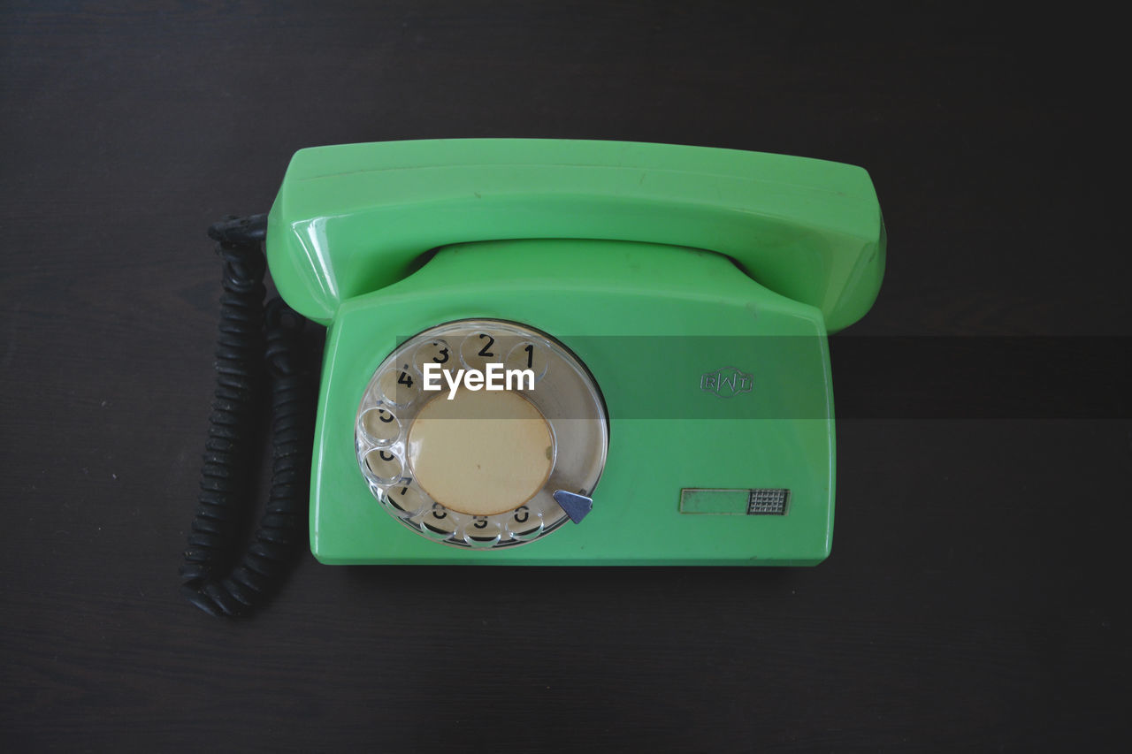 High angle view of green rotary phone on table