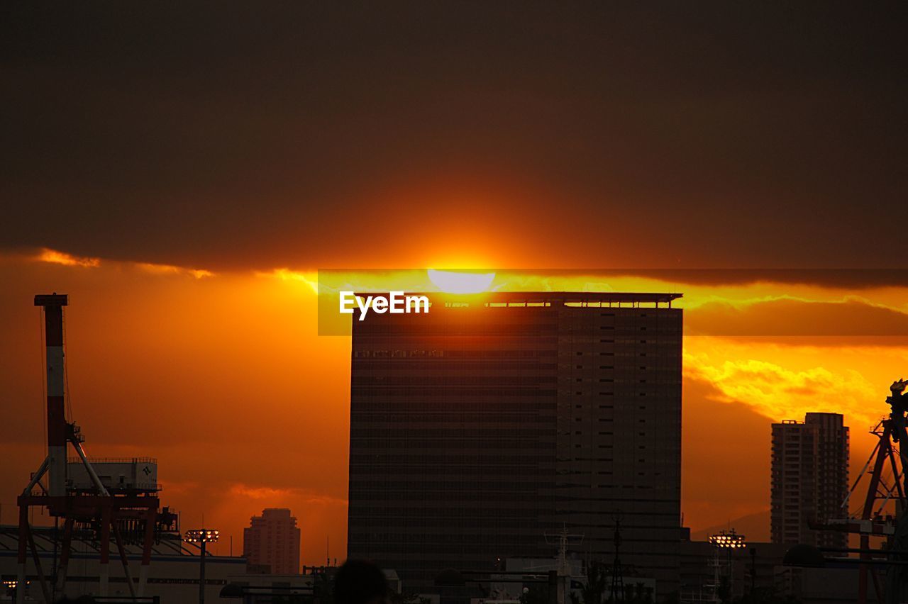 SILHOUETTE BUILDINGS AGAINST ORANGE SKY