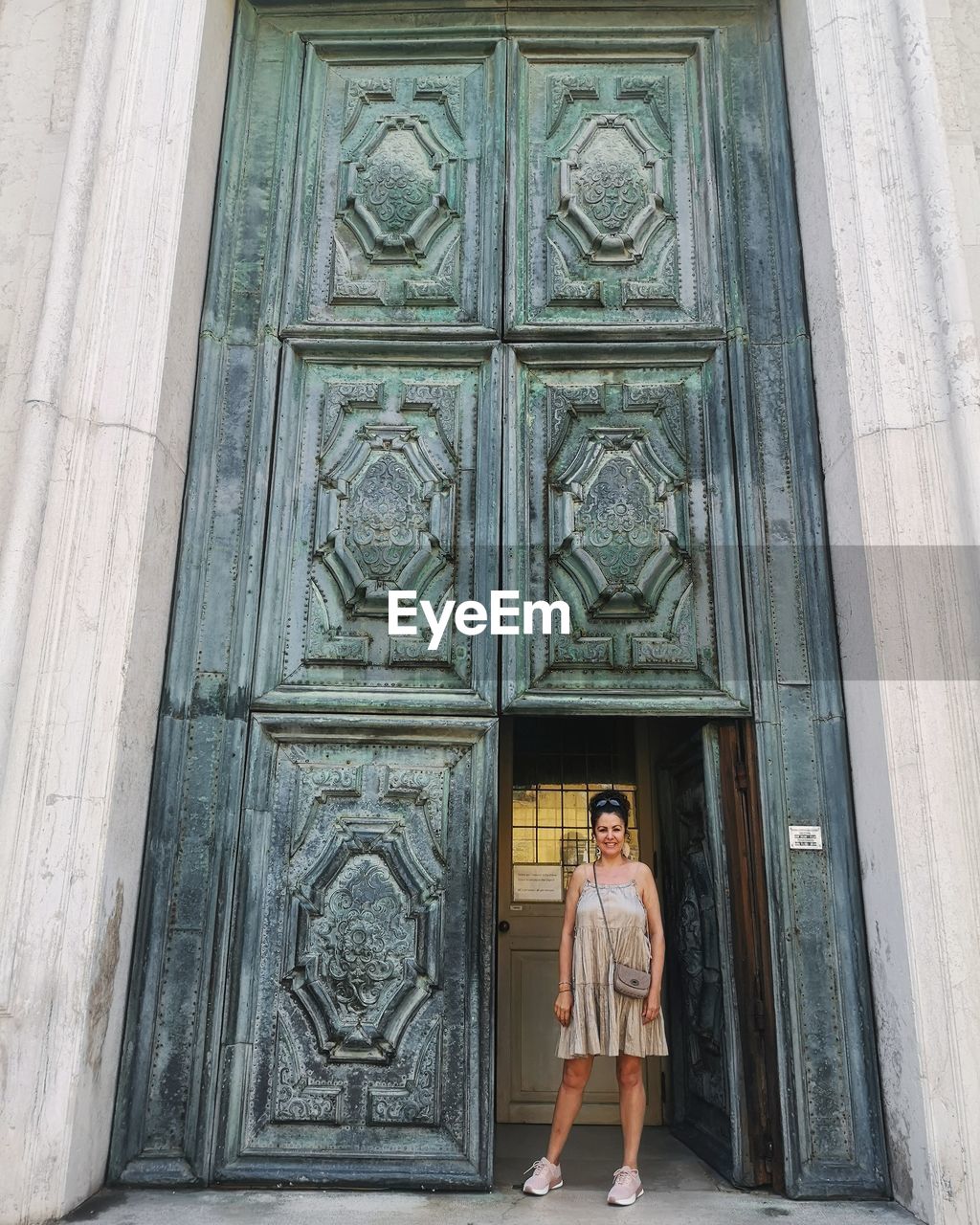 Portrait of woman standing against doorway