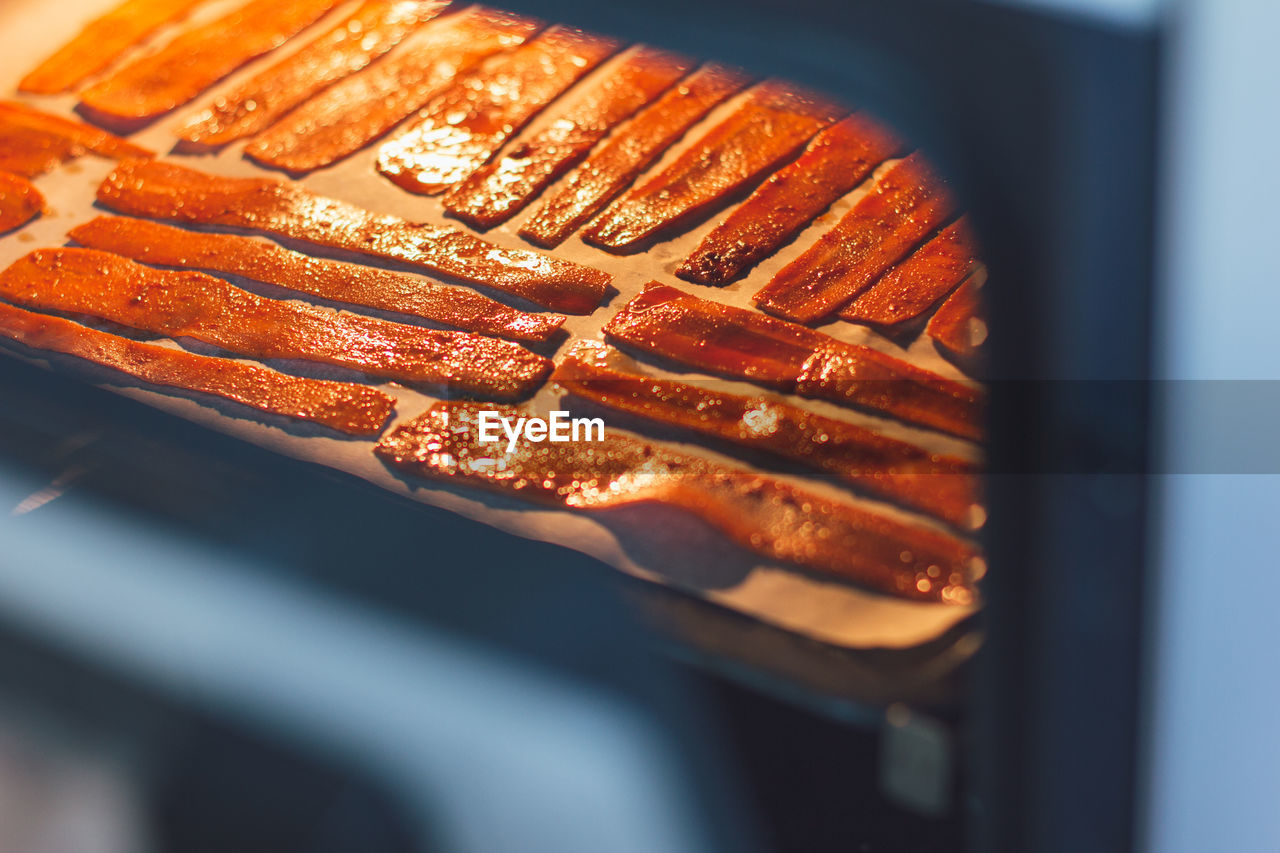 Sliced carrots in the oven on a protvin for cooking carrot bacon. vegetarian food, meat replacement