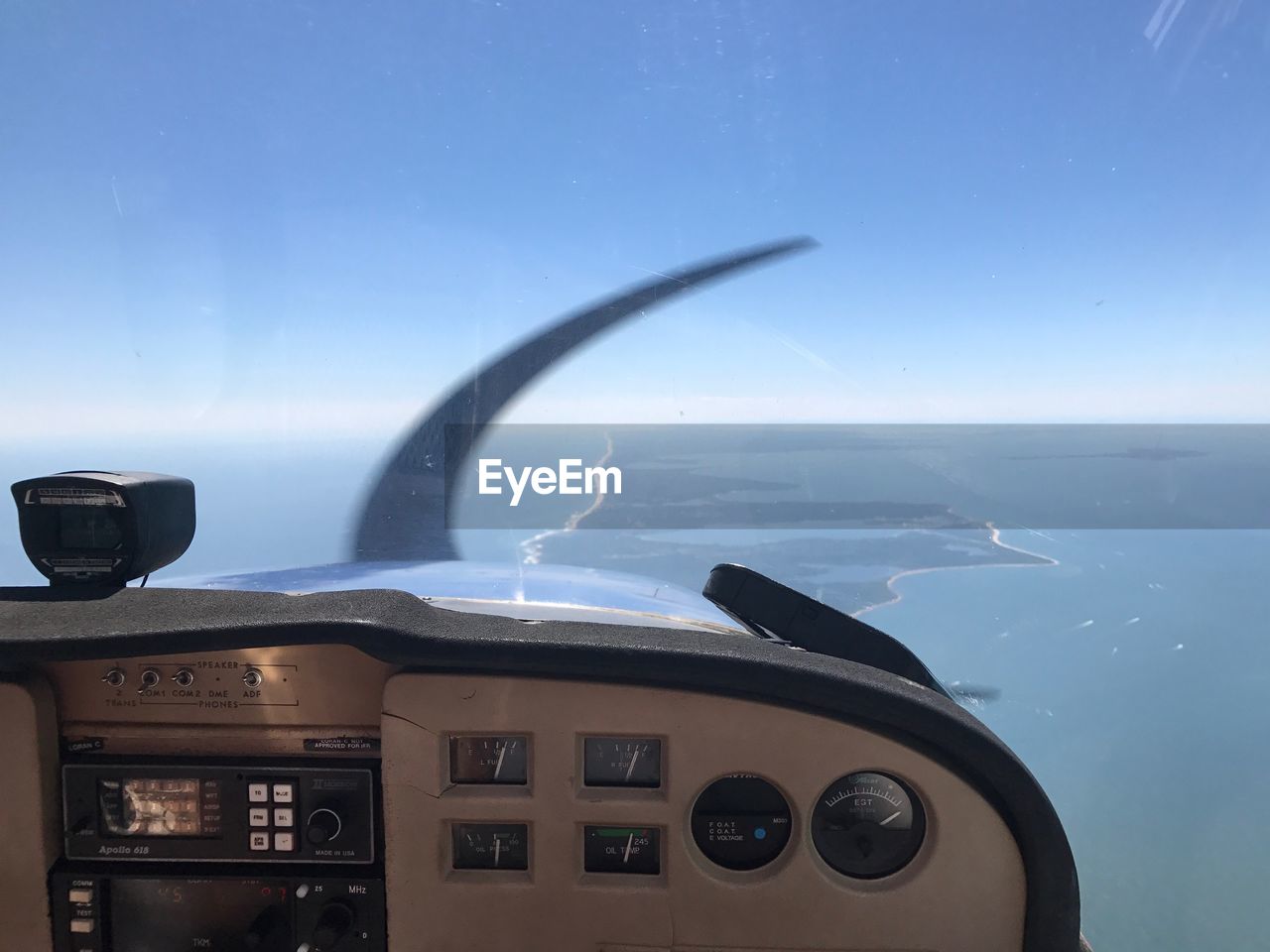 CLOSE-UP OF AIRPLANE FLYING ABOVE SEA AGAINST SKY