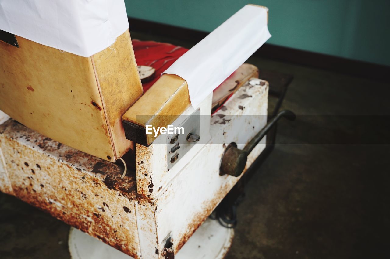 HIGH ANGLE VIEW OF RUSTY METAL BOX ON TABLE