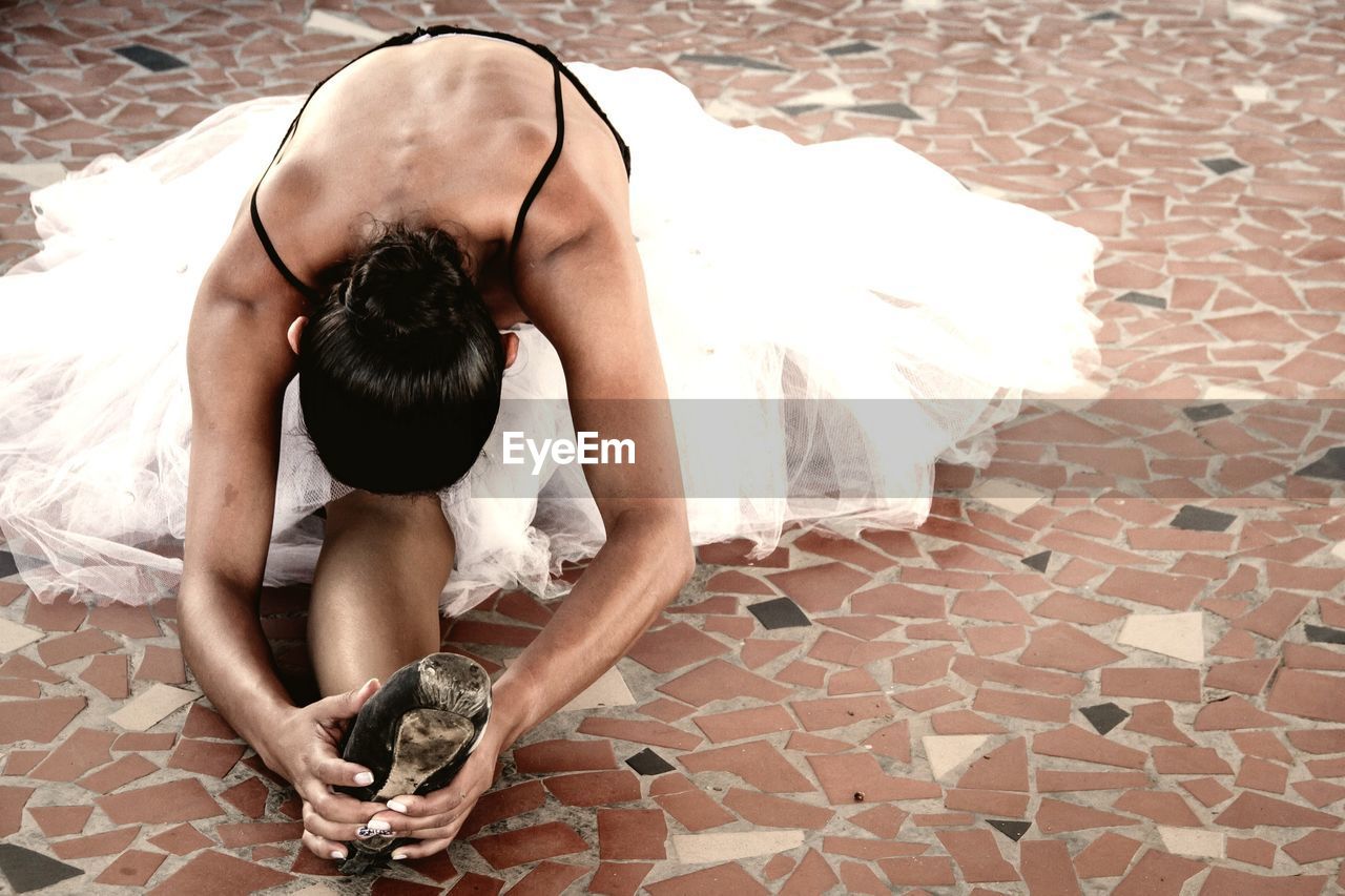 Woman dancing while sitting on floor