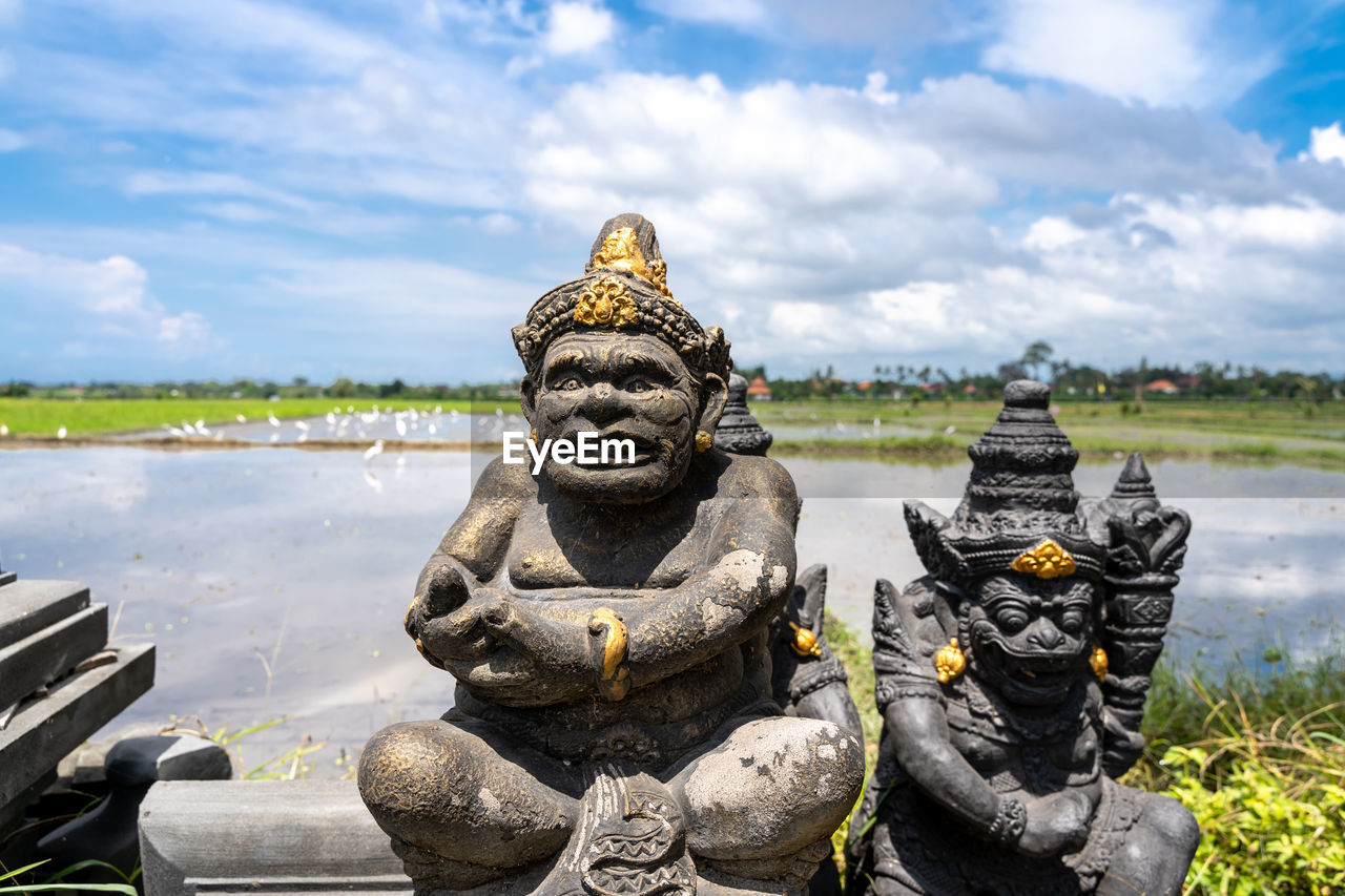 STATUE OF BUDDHA STATUES AGAINST SKY