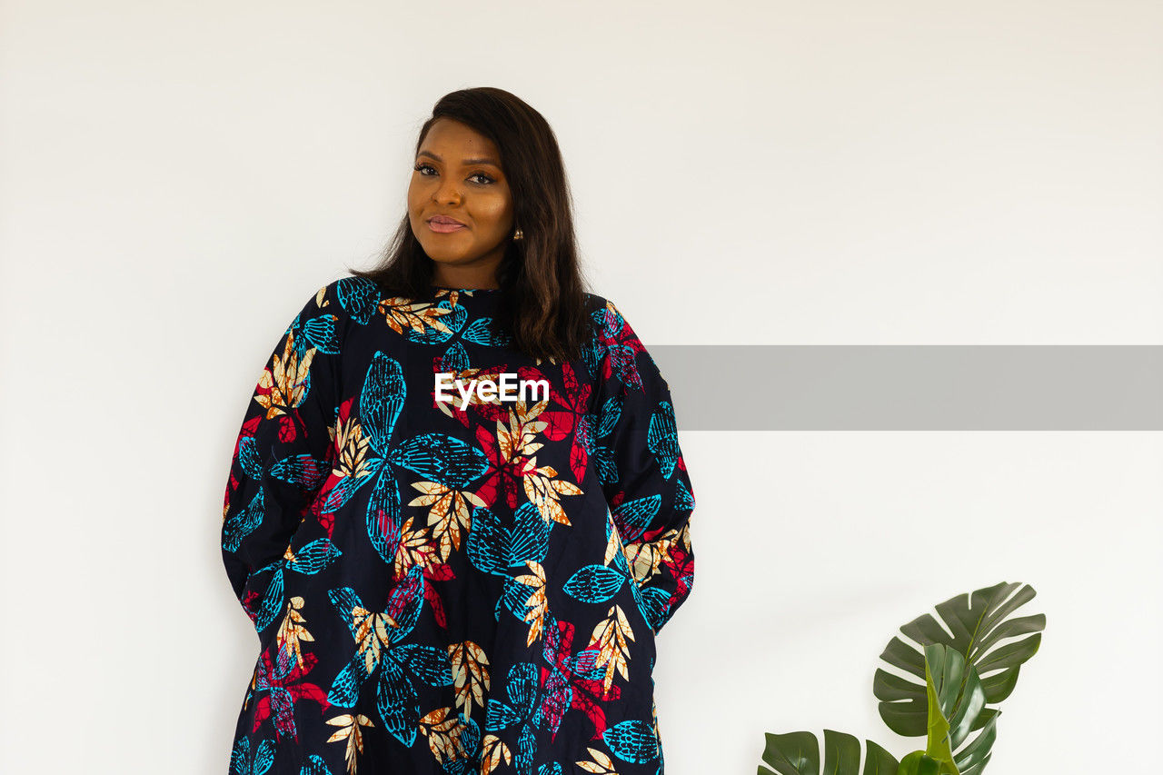 one person, women, adult, portrait, indoors, sleeve, clothing, young adult, smiling, copy space, studio shot, spring, photo shoot, waist up, flower, dress, outerwear, looking at camera, fashion, standing, white background, hairstyle, pattern, front view, happiness, female, lifestyles, three quarter length, nature, long hair, emotion, floral pattern, black hair, looking