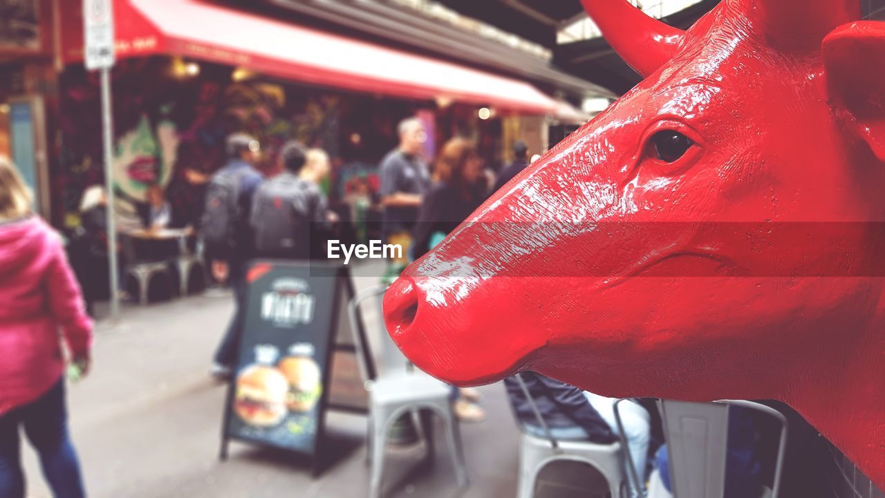 CLOSE-UP OF RED MAN IN MARKET STALL