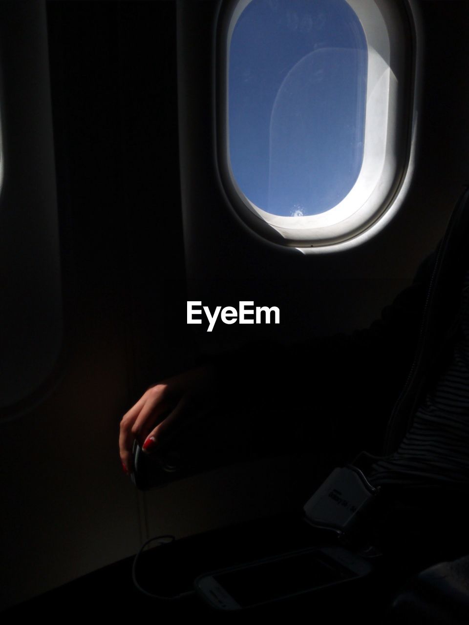 Cropped image of woman in airplane by window