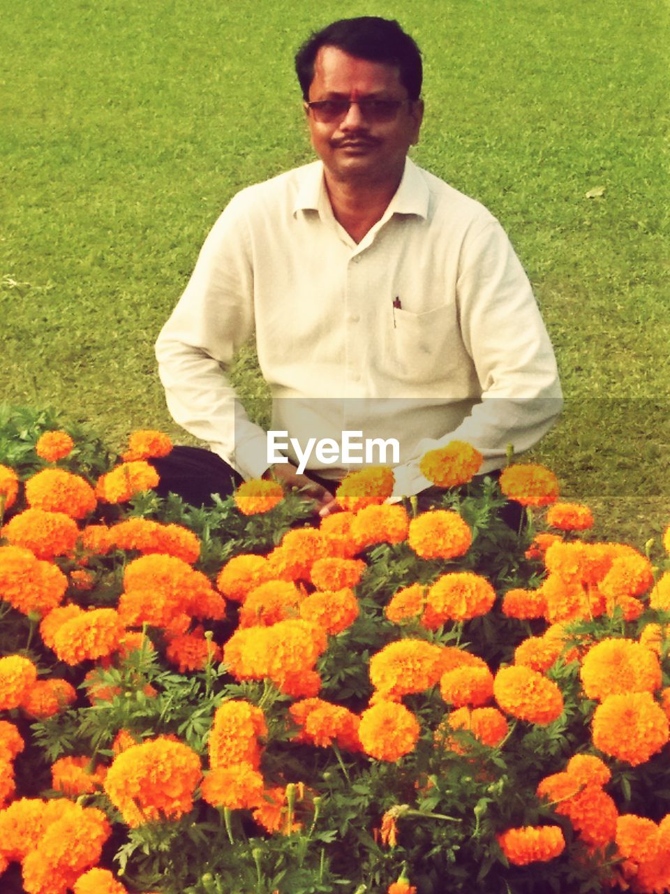 FULL LENGTH OF A MAN WITH YELLOW FLOWERS IN PARK