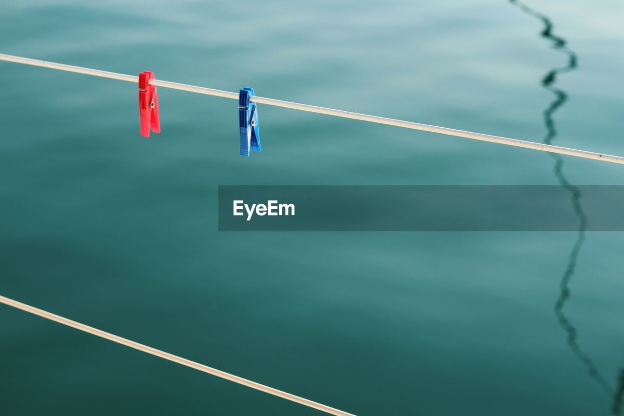 Low angle view of rope against blue water surface