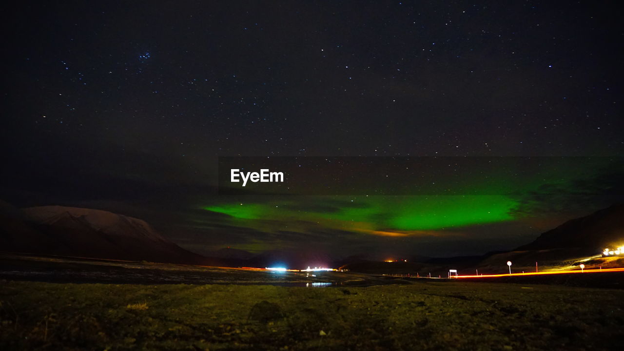 Scenic view of illuminated field against sky at night