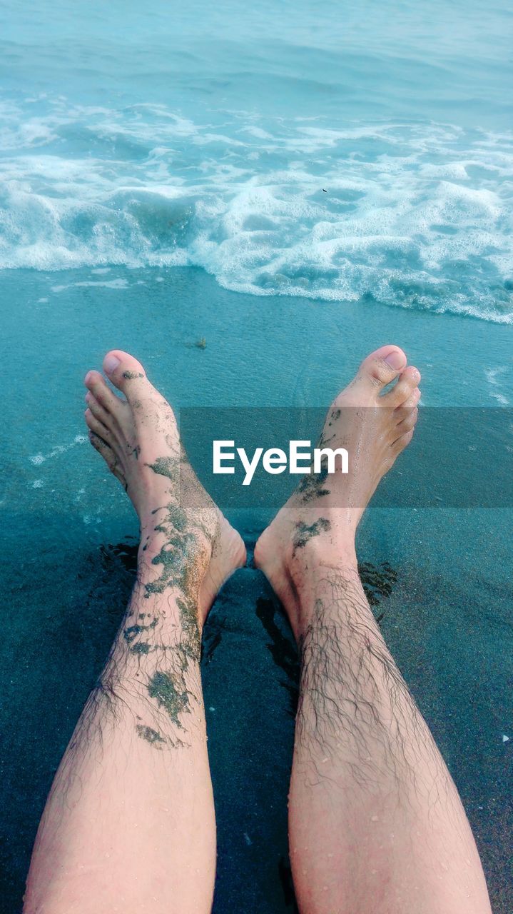 Low section of man resting at beach