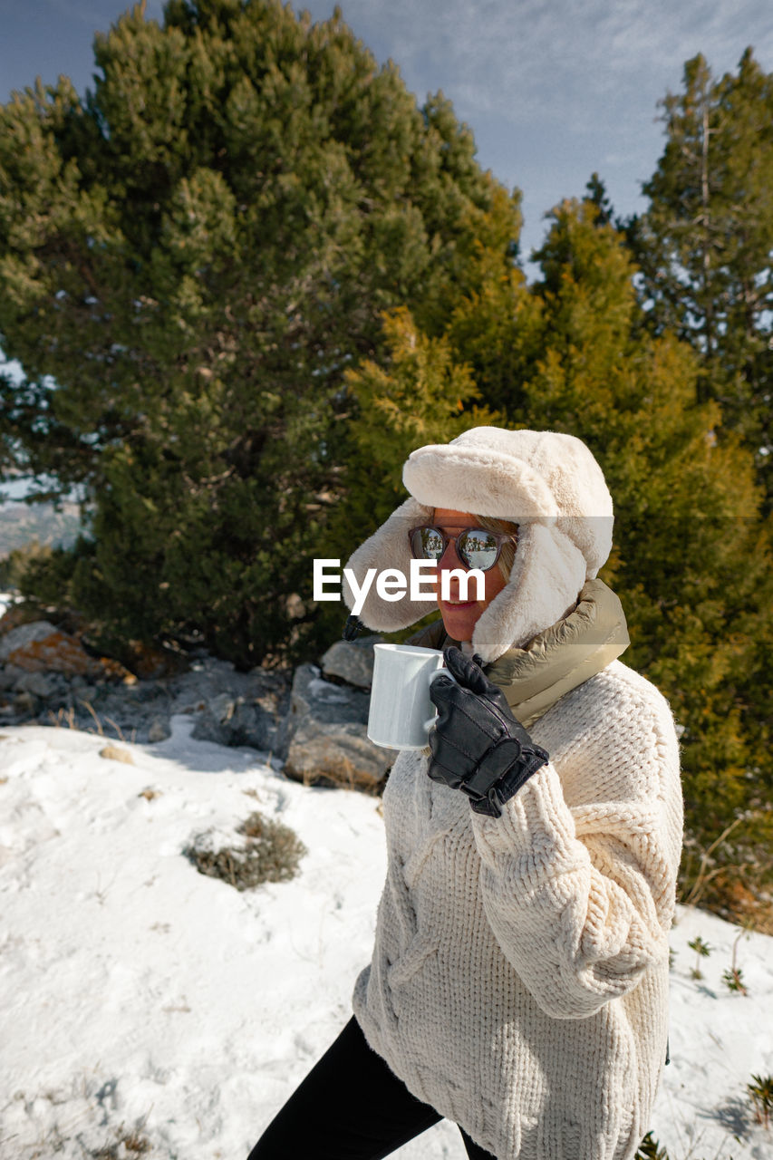 A beauty girl on the winter background with coffe cup.