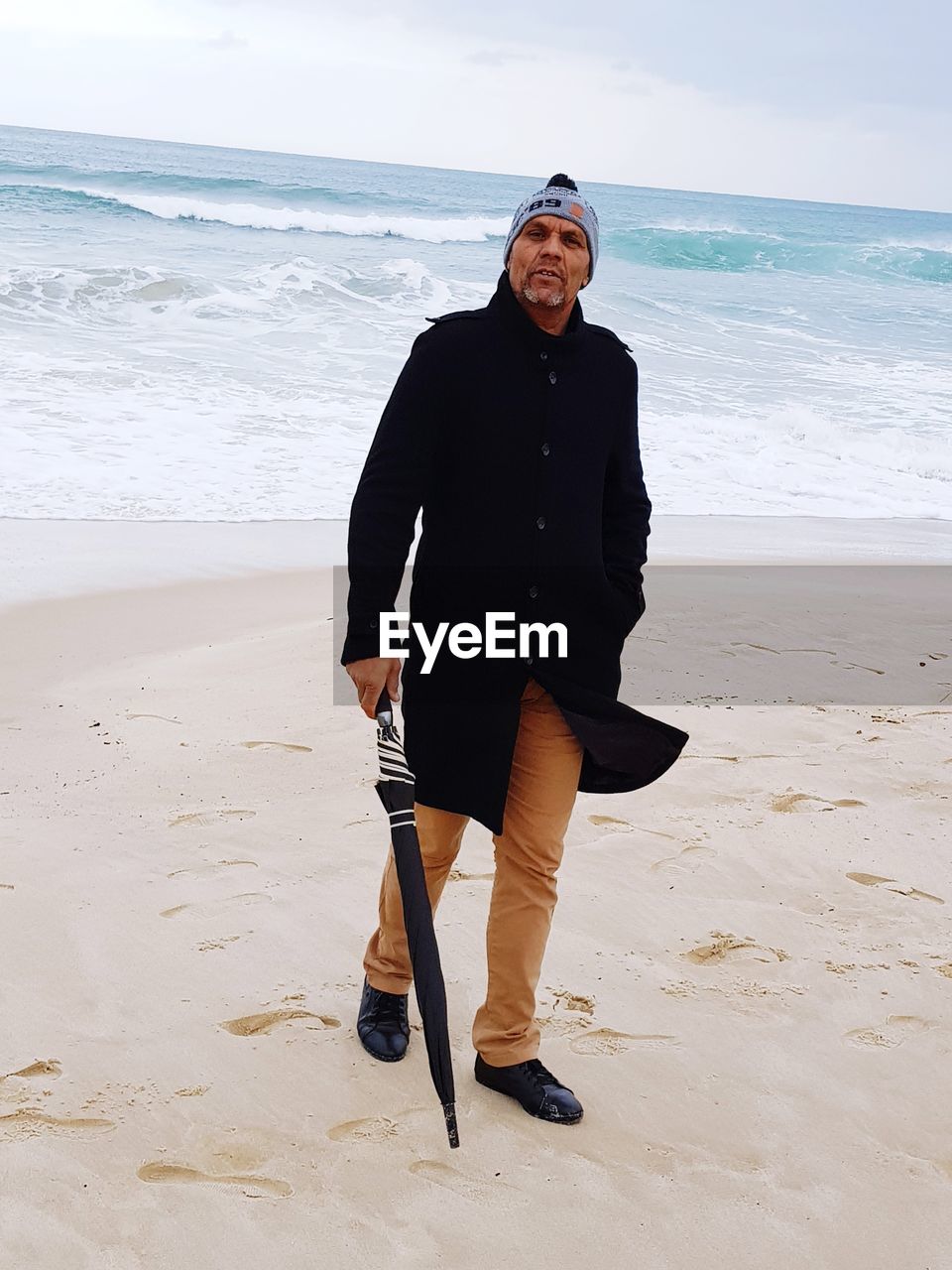 Full length portrait of man walking at beach