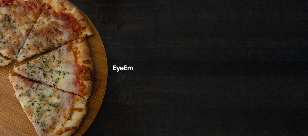 food and drink, fast food, food, pizza, indoors, freshness, wood, no people, cheese, copy space, directly above, italian food, table, still life, high angle view, slice, baked, dairy, dish, unhealthy eating, rustic, studio shot, close-up, bread, black background