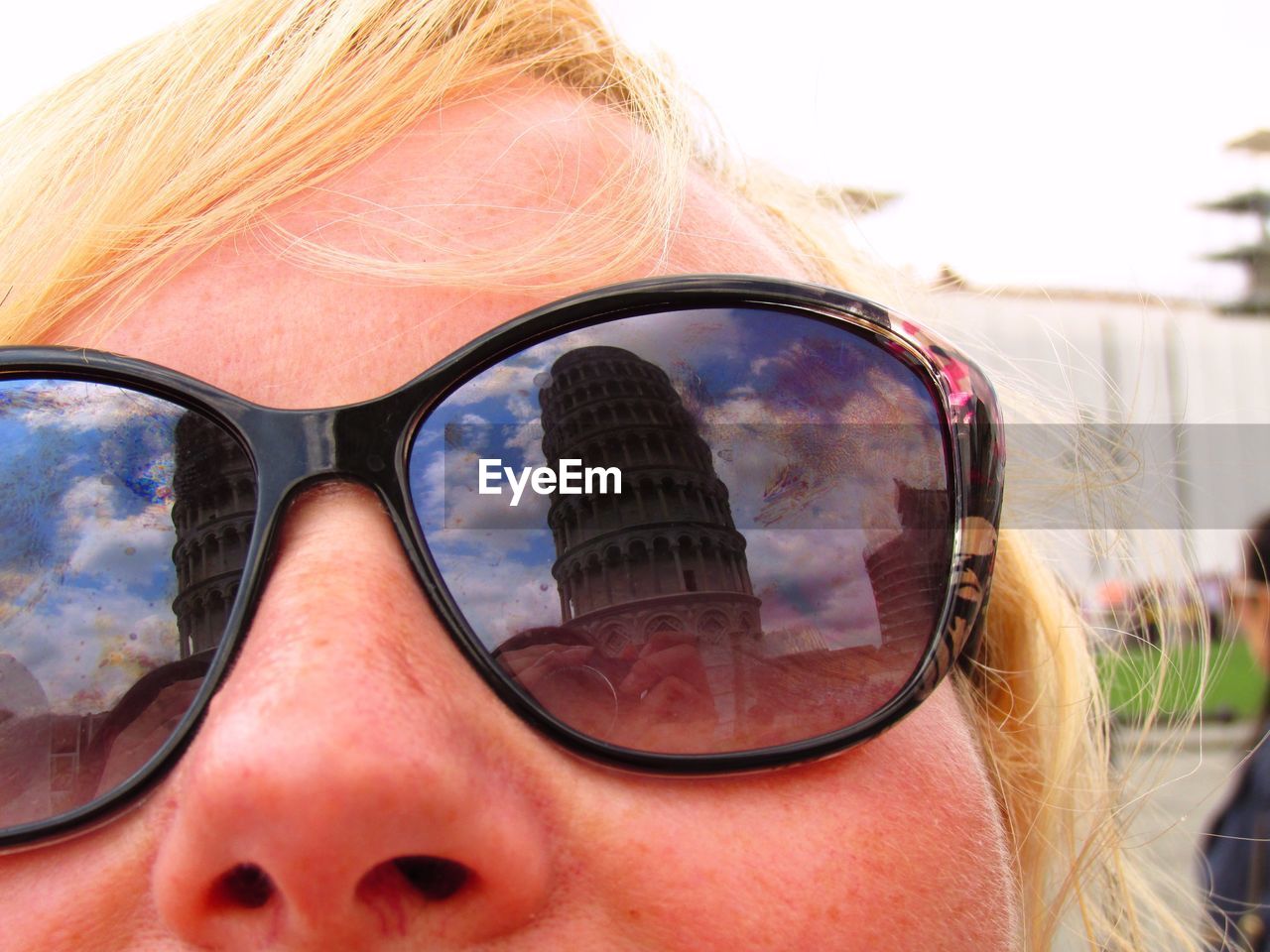 Reflection of leaning tower of pisa on woman sunglasses