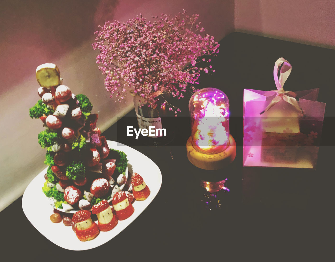 HIGH ANGLE VIEW OF PURPLE ROSES IN PLATE ON TABLE