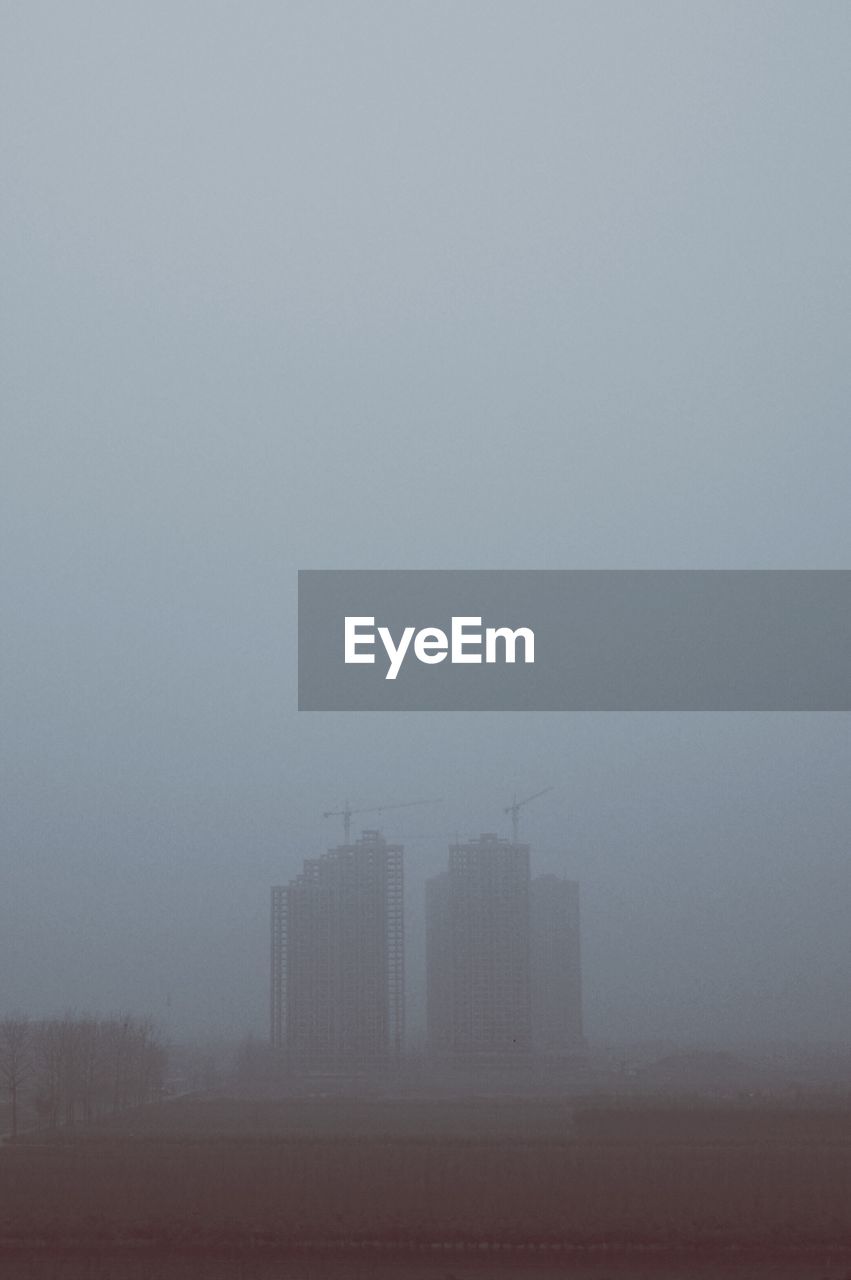 Buildings in city during foggy weather