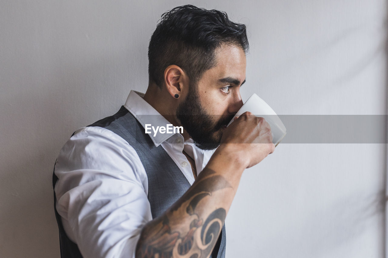 Handsome man dressed as executive drinking coffee
