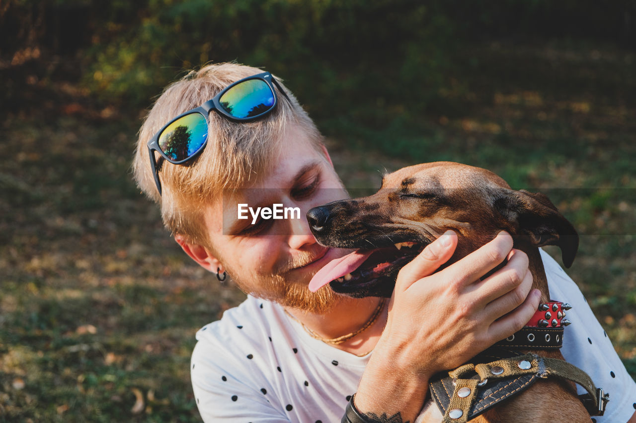 CLOSE-UP OF A MAN WITH DOG ON BEACH