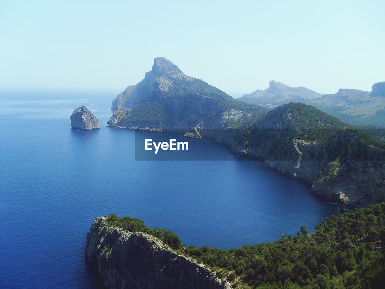 Scenic view of sea and mountains against sky