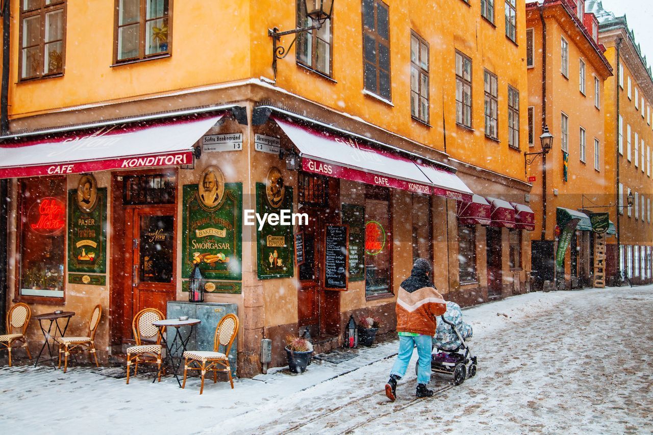 PEOPLE ON STREET BY BUILDING