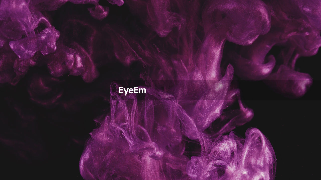 Close-up of purple liquid over black background