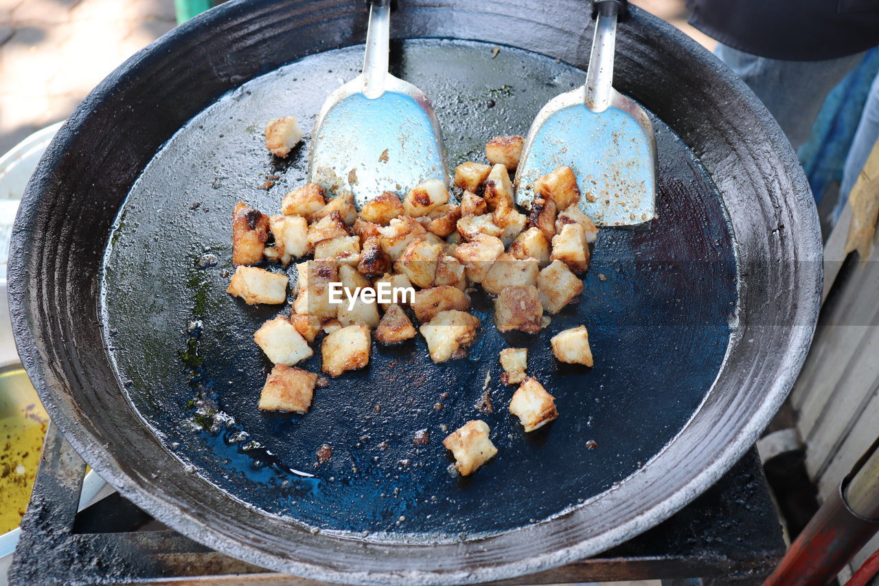 The food in a pan is fried radish cake or fried carrot is chinese made from steamed carrot cake