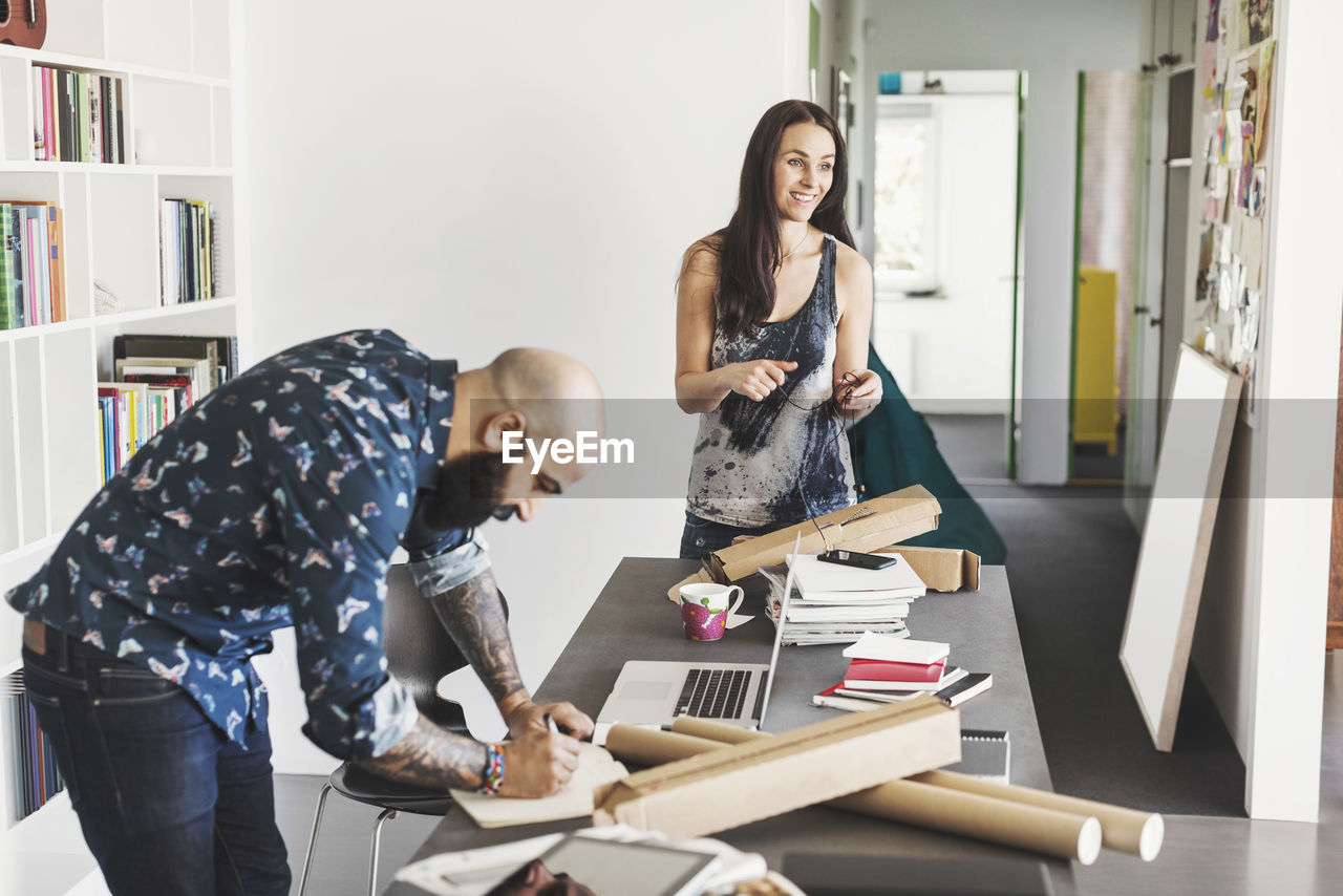 Male and female architects working at table